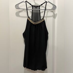 Blouse, top, black with gold, black and white accessory around the neck.